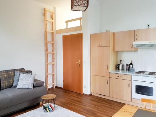 a living room with a couch and a kitchen at Stilvolle 1-Raum-Wohnung zentral, ruhig gelegen in Dresden