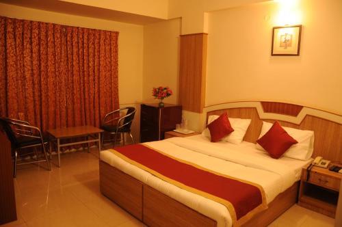 Habitación de hotel con cama, mesa y sillas en Srinidhi Residency Murugeshpalya en Bangalore
