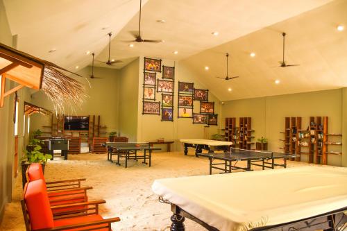 a large room with ping pong tables and chairs at Reethi Faru Resort - Stay 5 Nights or more & Enjoy a Free Sunset Cruise in Raa Atoll