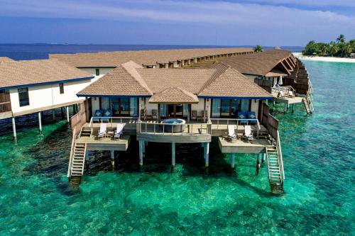 a house on the water in the middle of the ocean at Reethi Faru Resort - Stay 5 Nights or more & Enjoy a Free Sunset Cruise in Raa Atoll
