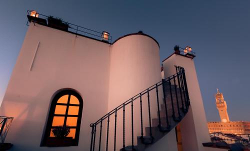 un escalier menant à un bâtiment doté d'une tour d'horloge dans l'établissement Hotel Torre Guelfa Palazzo Acciaiuoli, à Florence