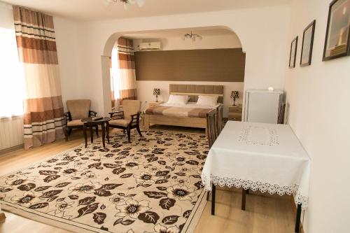 a bedroom with a bed and a table and a room with a bed sidx sidx at Mirage Hotel in Qyzylorda