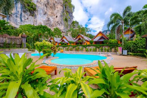 Diamond Cave Resort في شاطئ رايلي: منتجع فيه مسبح وجبل في الخلف