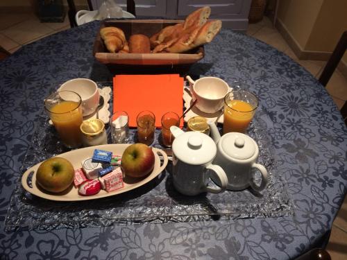 サントにあるLa parenthèseのリンゴ、パン、ティーポットの朝食付きテーブル
