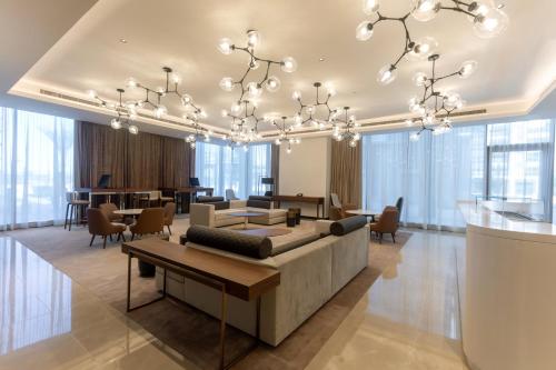 a living room with a chandelier and a table at Novotel Dubai Gold District in Dubai