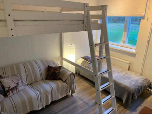 a living room with a bunk bed and a couch at Wanha Koulu Tahko Onnela, 4mh, Palju, Sauna, Tupakeittiö, Wifi, Liikuntasali, RinteetSpaRavintola 6km, Lemmikit OK, Edukas in Reittiö