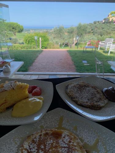 two plates of food on a table with a view at Relais dei Molini - Villa dei Molini in Castagneto Carducci