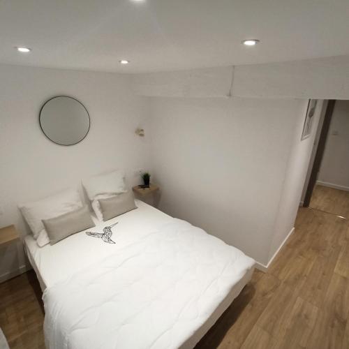 uma cama branca num quarto com um espelho em A 4 min du Zoo de Beauval La Maison à Partager Ch3 1er étage em Saint-Aignan