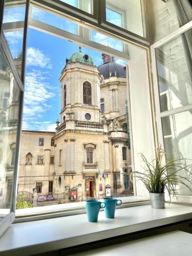 une fenêtre avec trois pots bleus sur un rebord de fenêtre dans l'établissement Dreaming Apartments, à Lviv