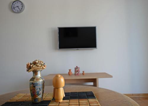 a room with a table with a vase and a table at Al Maha in Banja Koviljača