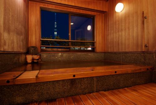 a wooden bench sitting in a room with a window at Ryokan Asakusa Shigetsu in Tokyo