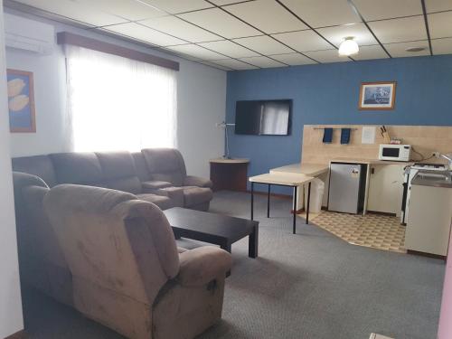 a living room with a couch and a table and a kitchen at Limestone Coast Tourist Park in Mount Gambier