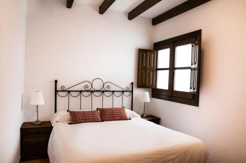 a bedroom with a large white bed and a window at tuGuest Carataunas Apartment Alpujarra in Carataunas