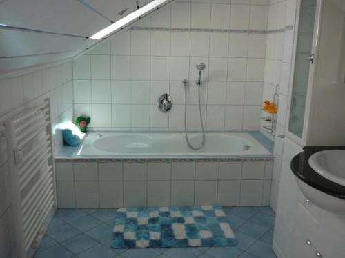 a bathroom with a tub with a shower and a toilet at Ferienwohnung am Ludwigstein in Spiegelau