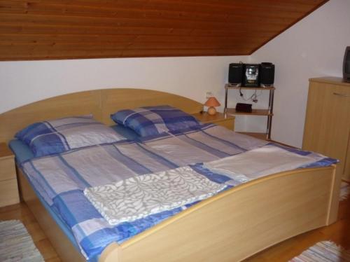 a bedroom with a bed with a wooden head board at Ferienwohnung am Ludwigstein in Spiegelau