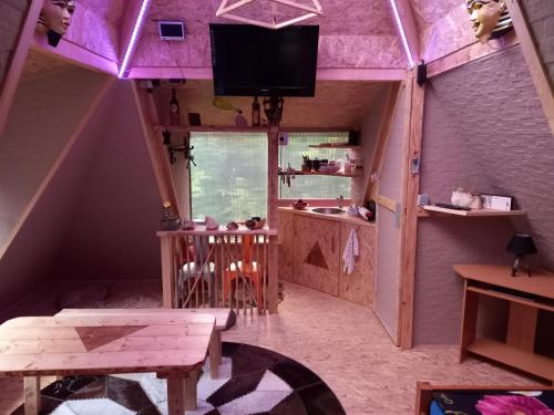 a room with a purple ceiling with a table and a tv at Holiday Home Nature Neno in Visoko
