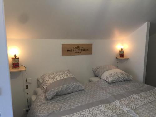 - une chambre avec deux lits et deux lumières sur le mur dans l'établissement Le Clos Moussy, à Moussy