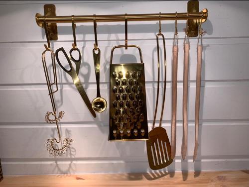 a group of kitchen utensils hanging on a wall at The Yellow House in Bamble