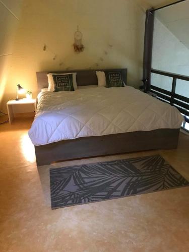 um quarto com uma cama grande e um tapete em Loft rénové au calme à la campagne pour famille em Hastière-par-delà