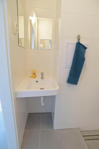 a white bathroom with a sink and a mirror at Apartmány Karviná in Karviná