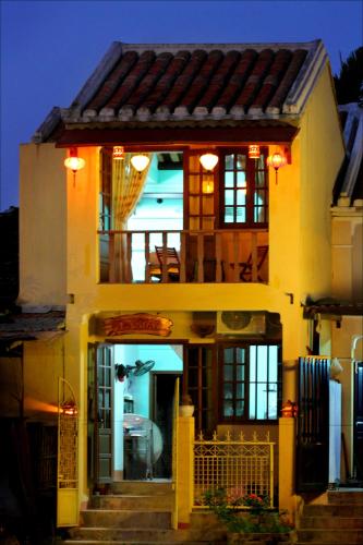 a house with stairs leading to the front of it at Nha Lan Homestay in Hoi An