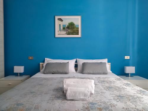 ein blaues Schlafzimmer mit einem großen Bett und einer blauen Wand in der Unterkunft A casa di Leda in Sarzana