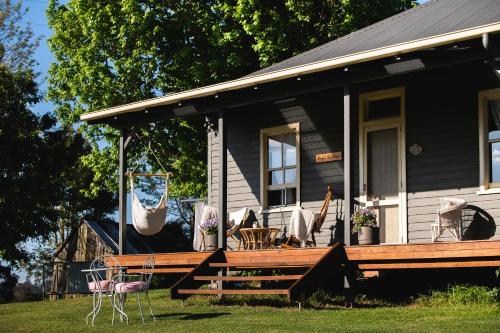 a black house with a porch with chairs on it at Fay's Cottage in Dorrigo