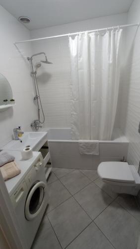 een witte badkamer met een toilet en een douche bij Apartament Buk in Rivne