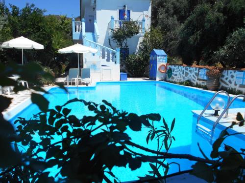 une piscine bleue avec des chaises et des parasols dans l'établissement Meltemia Studios, à Marathokampos