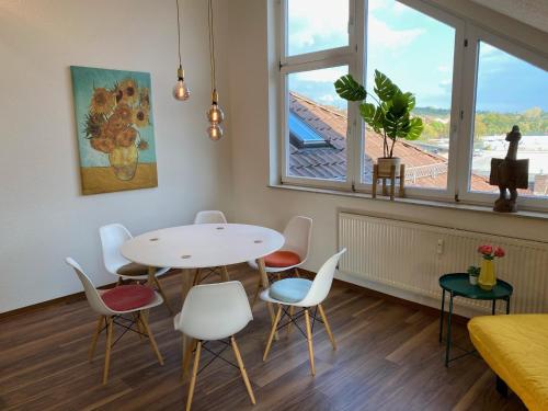 um quarto com uma mesa e cadeiras e uma janela em Sonnige Wohnung im Herzen von Marbach em Marbach am Neckar
