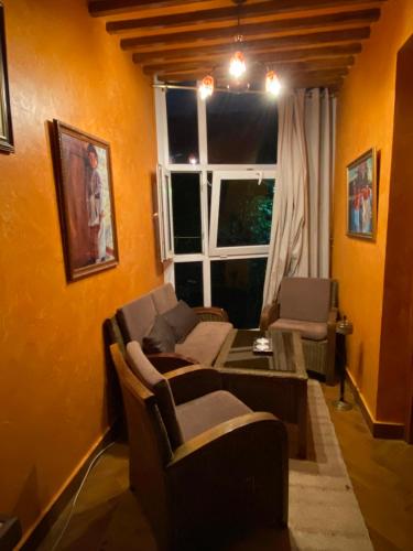a living room with a couch and a window at Très joli appartement au centre de IFRANE in Ifrane