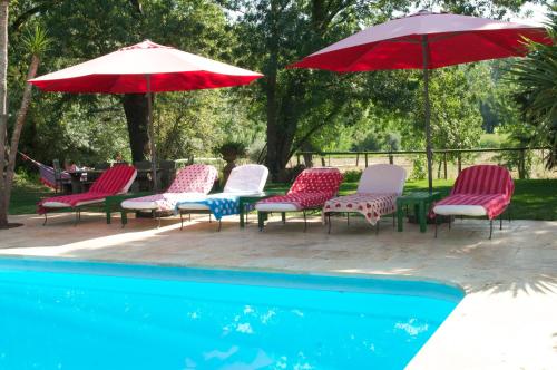 a group of chairs and umbrellas next to a pool at Can Portell by 123ole, B&B - Casa Rural in Sant Andreu del Terri