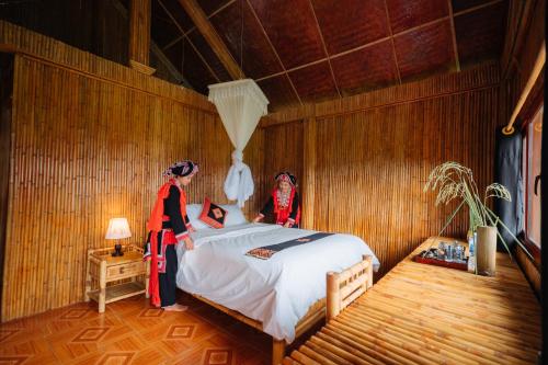 two women standing in a room with a bed at Hoang Su Phi Lodge in Ha Giang