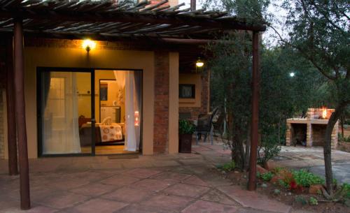 a house with a door open to a patio at Baobab - NUDE - SunEden Family Naturist Resort in Pretoria