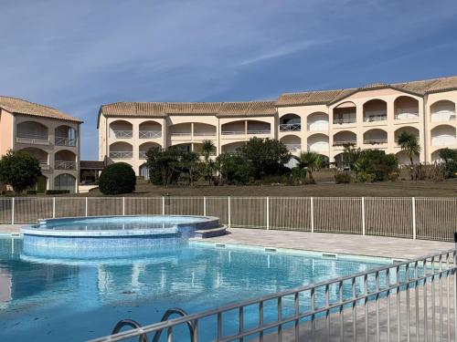 uma grande piscina em frente a um edifício em Appartement T2 cabine, capacité 4 personnes, à 600 m de la plage et à 300 m du Golf em Moliets-et-Maa