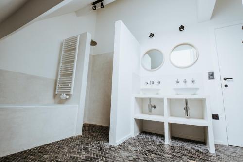 ein Badezimmer mit zwei Waschbecken und zwei Spiegeln in der Unterkunft 79 Graaf Jansdijk in Knokke-Heist