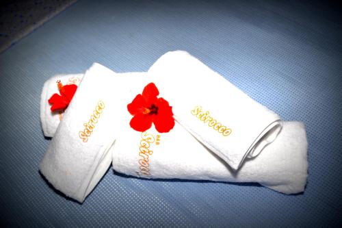 two white towels with red flowers on them at Scirocco in Cefal&ugrave;