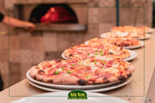 three pizzas sitting on top of a table at Hotel Valle Verde in Grammichele