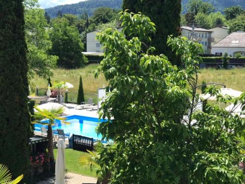 a view of a swimming pool in a yard at Ferienanlage Seehof in Krumpendorf am Wörthersee