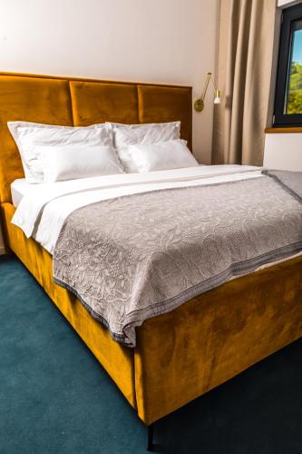 a bedroom with a large wooden bed with white pillows at Olive Tree mansion in Vir