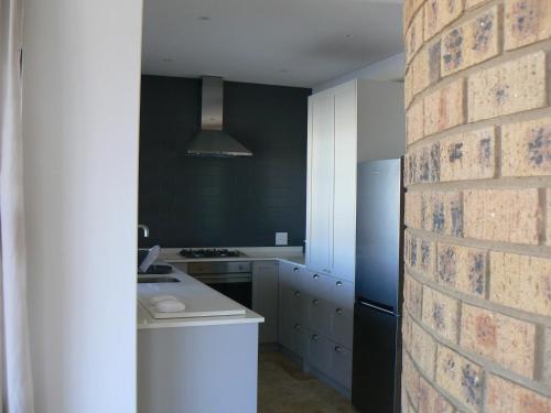 a kitchen with a brick wall and a kitchen with a stove at The Don Lodge in Amanzimtoti