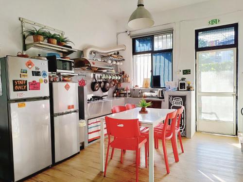 una cucina con tavolo bianco e sedie rosse di 都蘭朋友家 Dulan Friends Hostel a Donghe