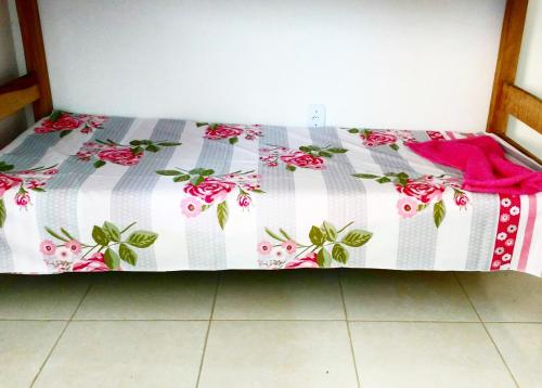 a bed with a pink and white quilt on it at Guarajuba sitiofelizcidade in Guarajuba
