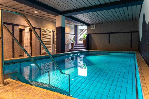 a swimming pool with a pool table and a tub at Parkhotel Sonnenhof in Oberammergau