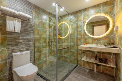 a bathroom with a shower and a toilet and a sink at Yangshuo Yi Landscape Hotel in Yangshuo