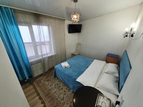 niewielka sypialnia z niebieskim łóżkiem i oknem w obiekcie Bucuresti Apartment Studio w Kiszyniowie
