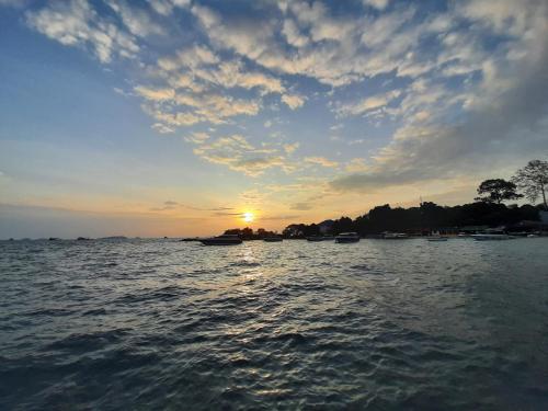 a sunset over a body of water with boats at Runa Runa The Best Samed Island in Ko Samed