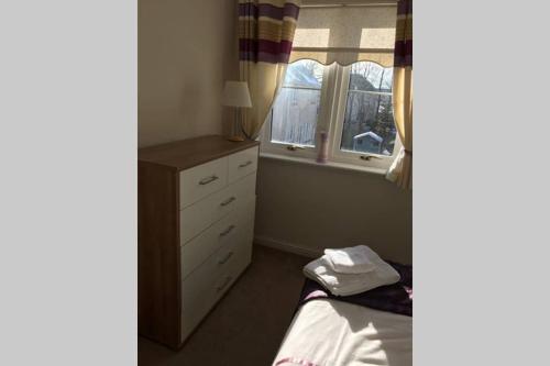 a small bedroom with a bed and a window at Kingseat 3 Bed Home With Fast Fibre WiFi &Parking in Newmachar