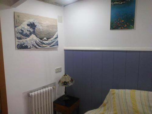 a bedroom with a painting of a wave on the wall at Casita para dos con piscina privada in Torres