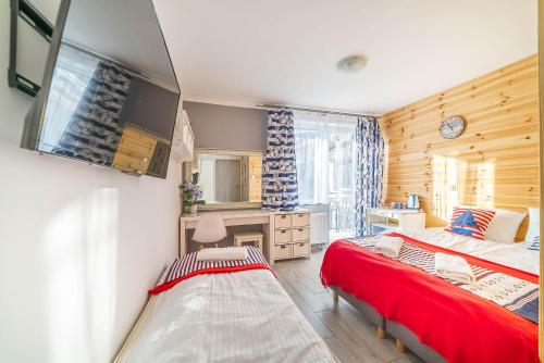 a bedroom with two beds and a bathroom with a tv at Blu Mare in Władysławowo